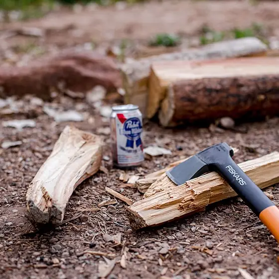 An axe resting beside freshly split firewood